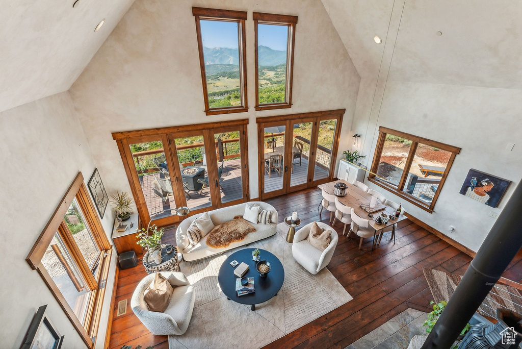 Living room featuring hardwood / wood-style flooring, a mountain view, french doors, and high vaulted ceiling