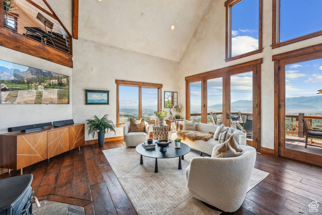 Living room featuring a mountain view, french doors, hardwood / wood-style flooring, and high vaulted ceiling