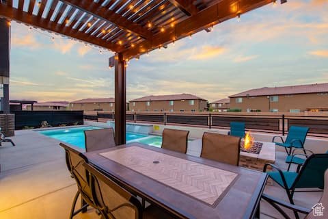 Patio terrace at dusk featuring a fenced in pool, a pergola, and a fire pit