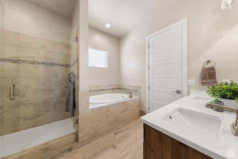 Bathroom featuring vanity, separate shower and tub, and wood-type flooring