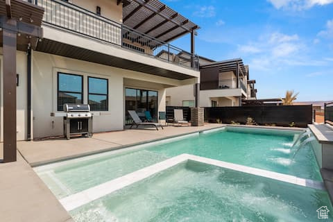 View of pool with grilling area, pool water feature, and a patio area