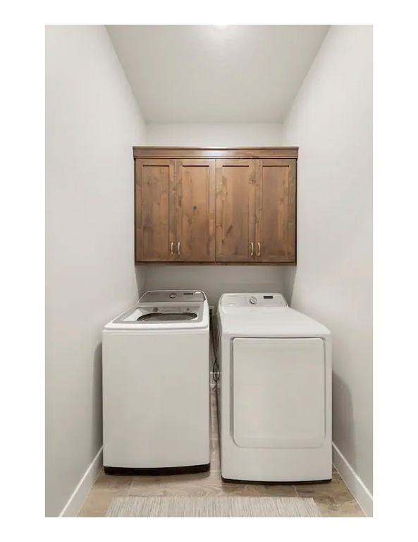 Clothes washing area with separate washer and dryer and cabinets