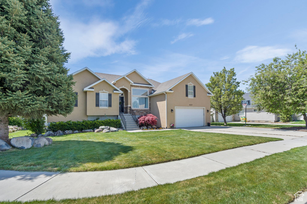 View of front of property with a garage and a front lawn