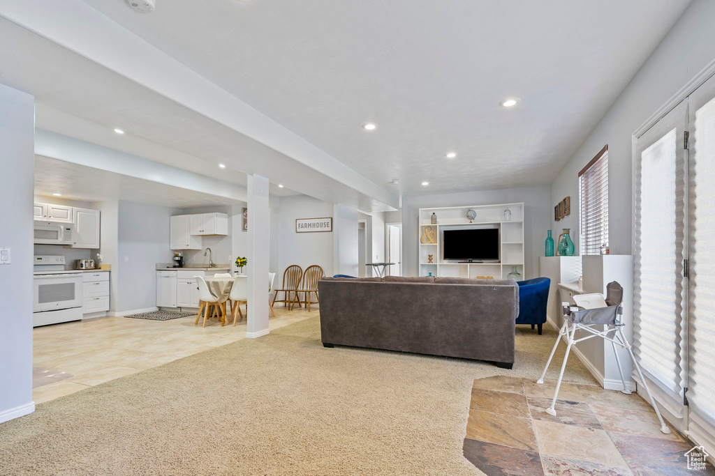 Living room with sink, light carpet, and a wealth of natural light