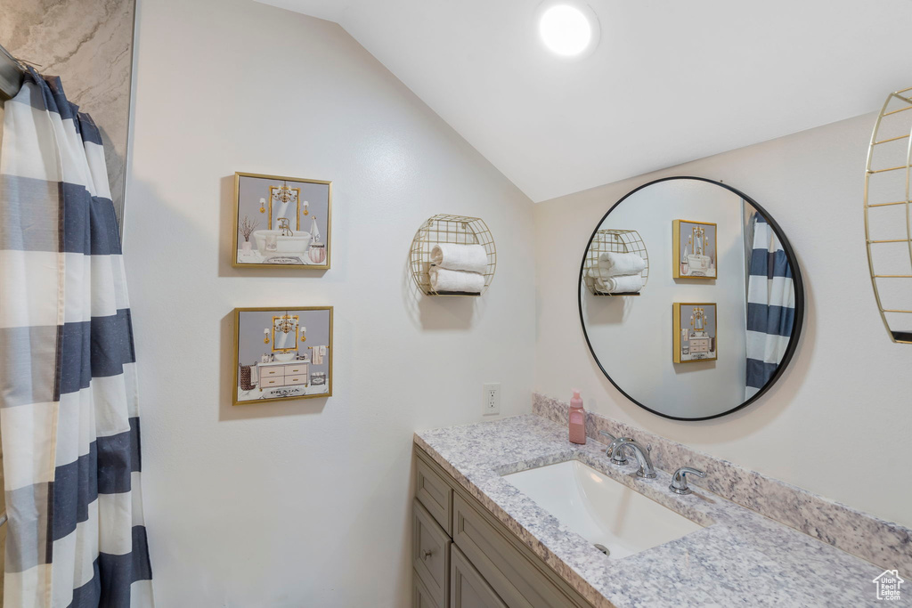 Bathroom featuring vanity and vaulted ceiling