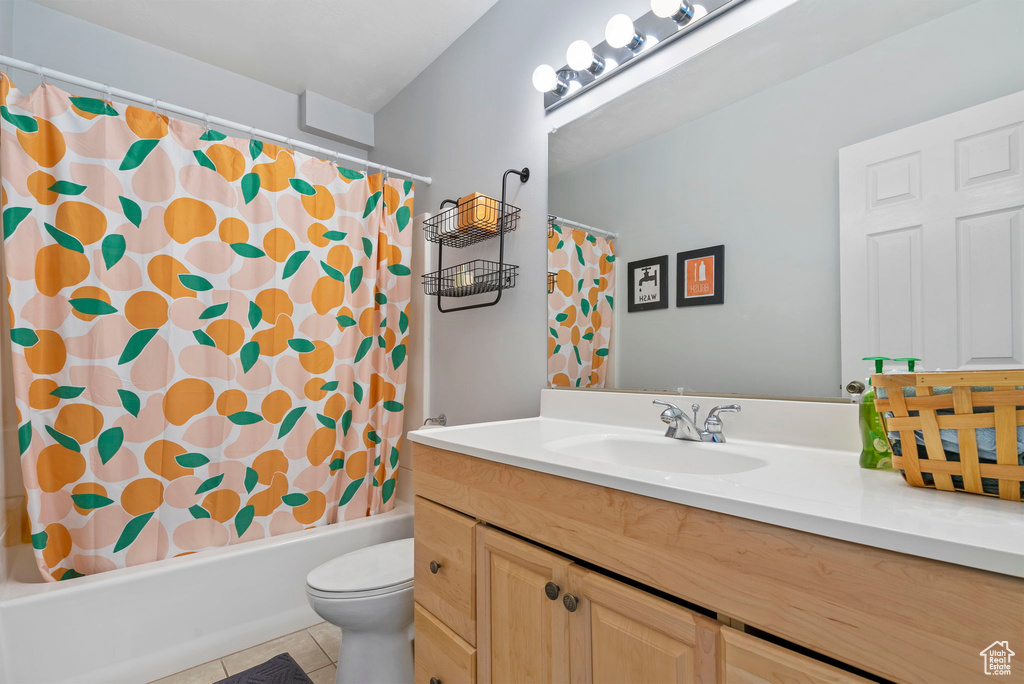 Full bathroom featuring shower / tub combo, tile patterned flooring, toilet, and vanity