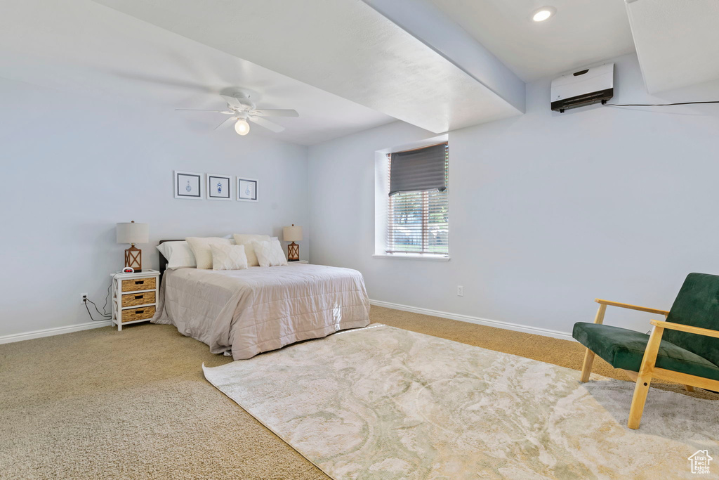 Carpeted bedroom with a wall unit AC and ceiling fan