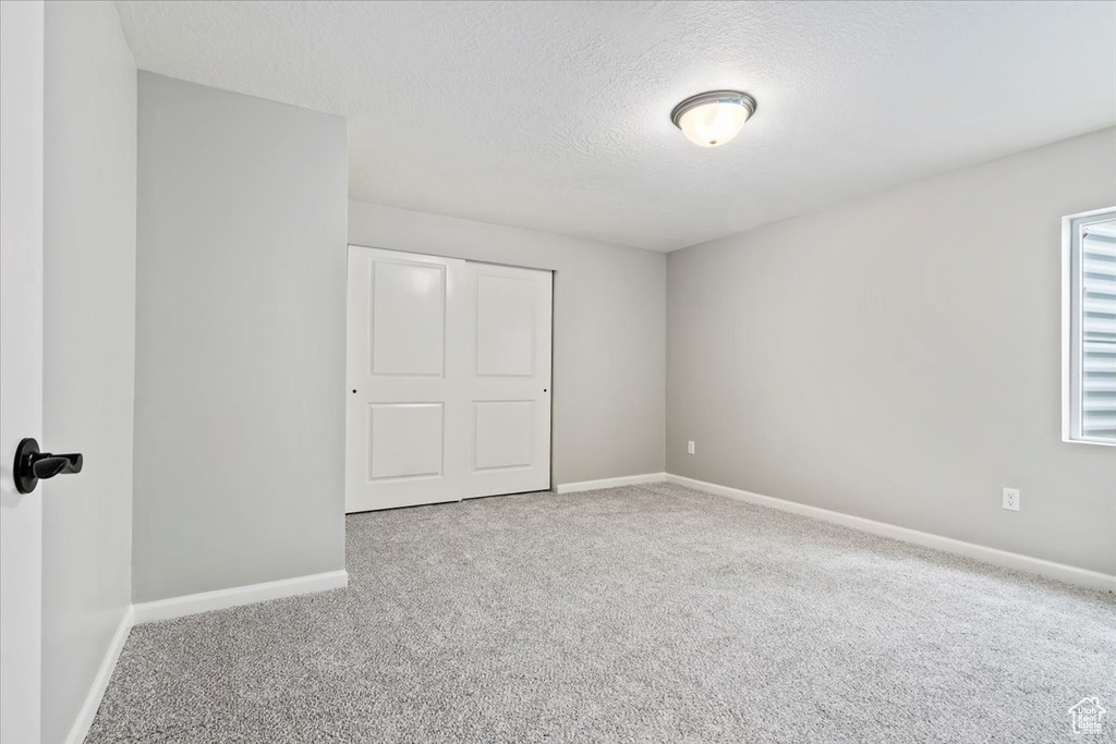 Unfurnished bedroom with carpet and a textured ceiling