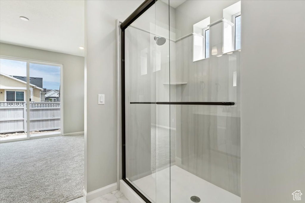 Bathroom featuring a shower with shower door and tile patterned floors