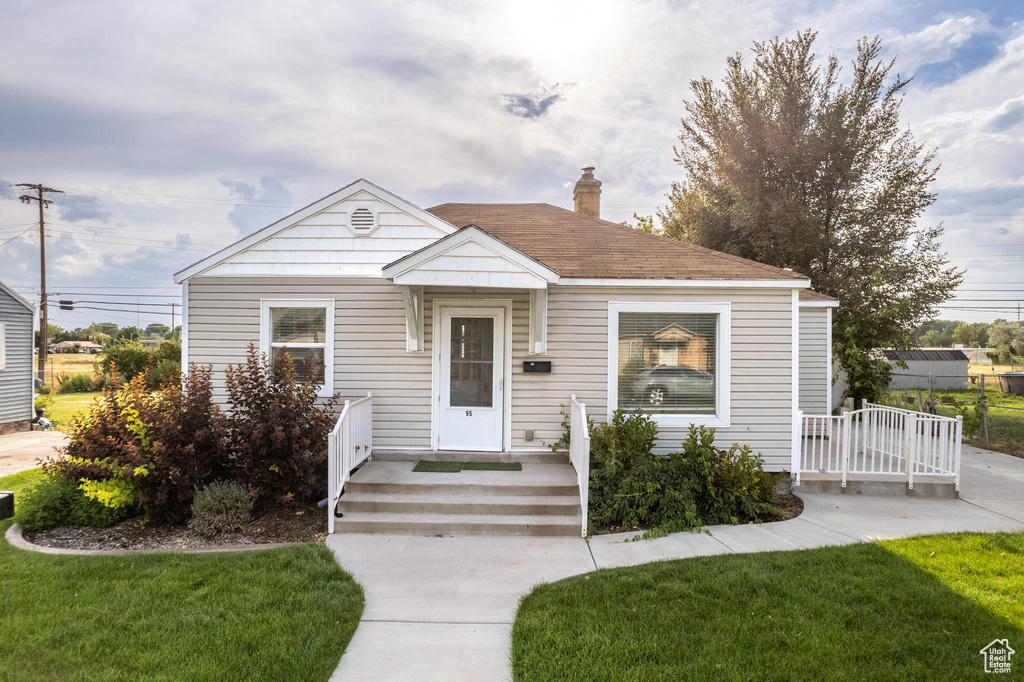 Bungalow-style home with a front lawn