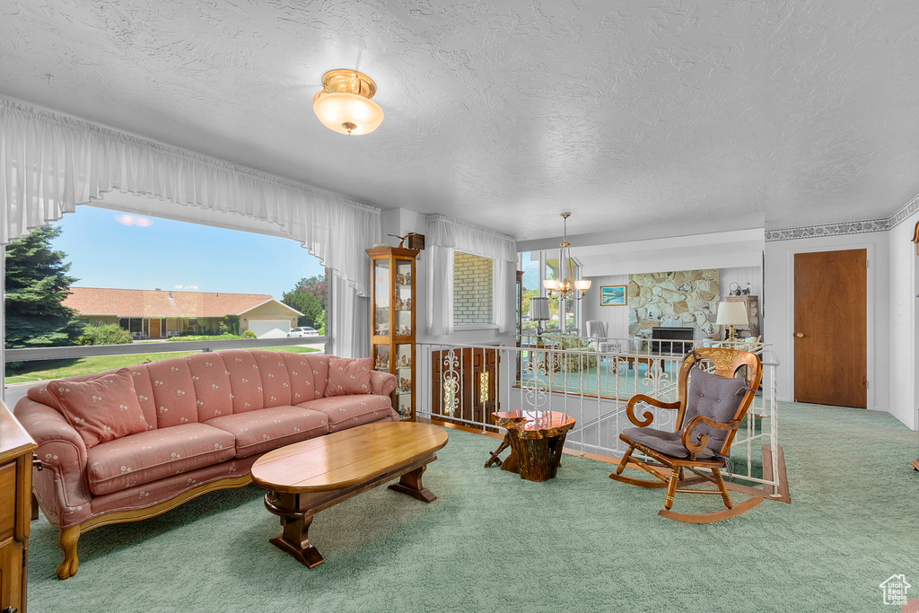 Carpeted living room featuring a textured ceiling and a chandelier