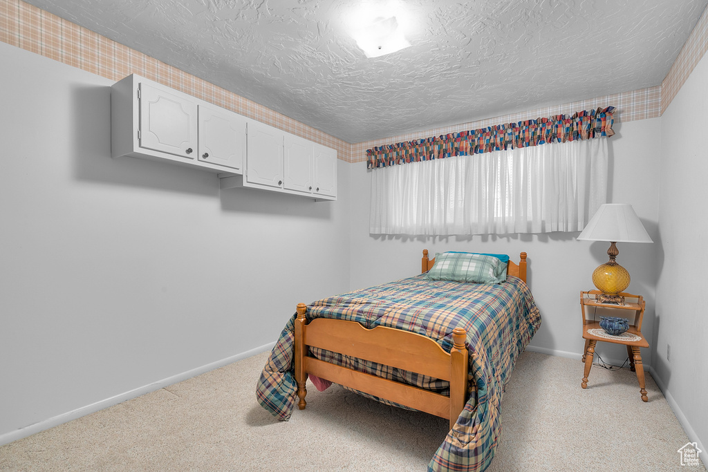 Carpeted bedroom with a textured ceiling