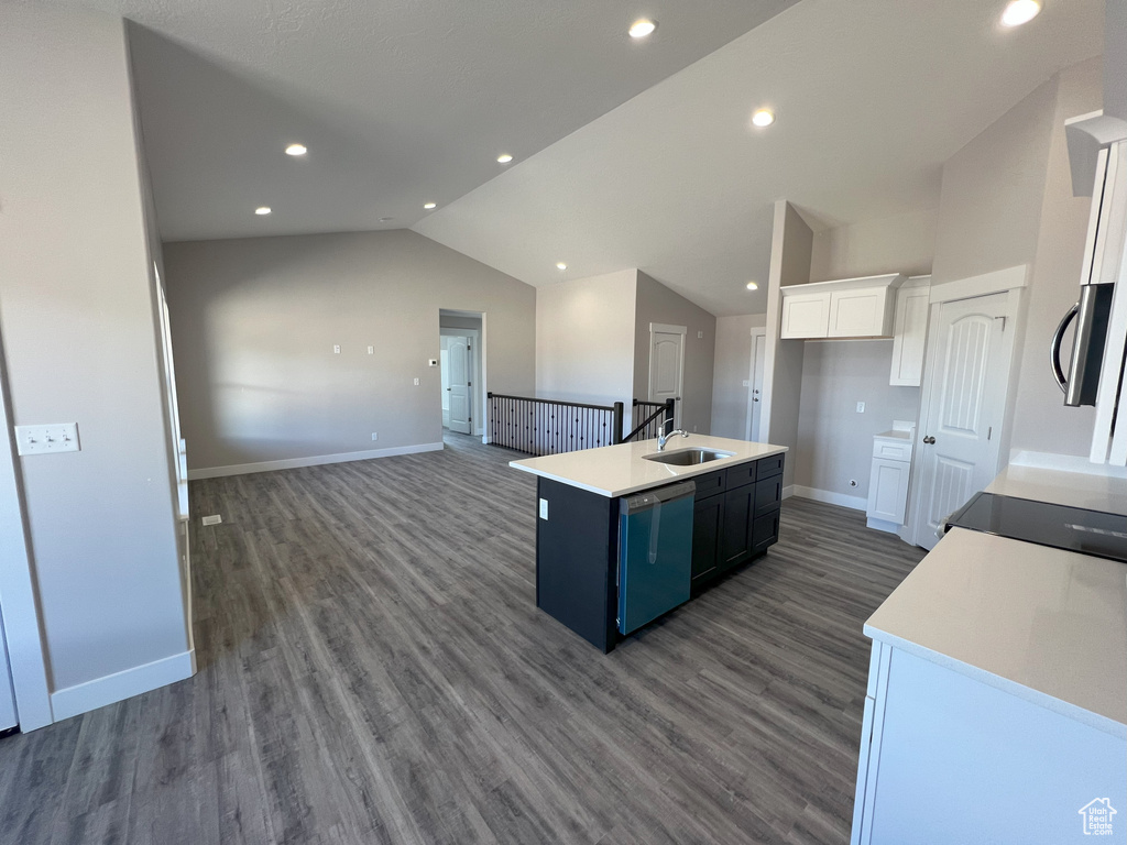 Kitchen featuring white cabinets, hardwood / wood-style flooring, appliances with stainless steel finishes, and a kitchen island with sink