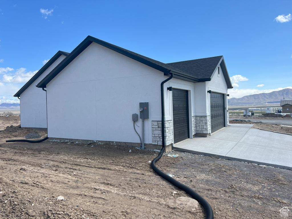 View of side of property featuring a garage and a mountain view