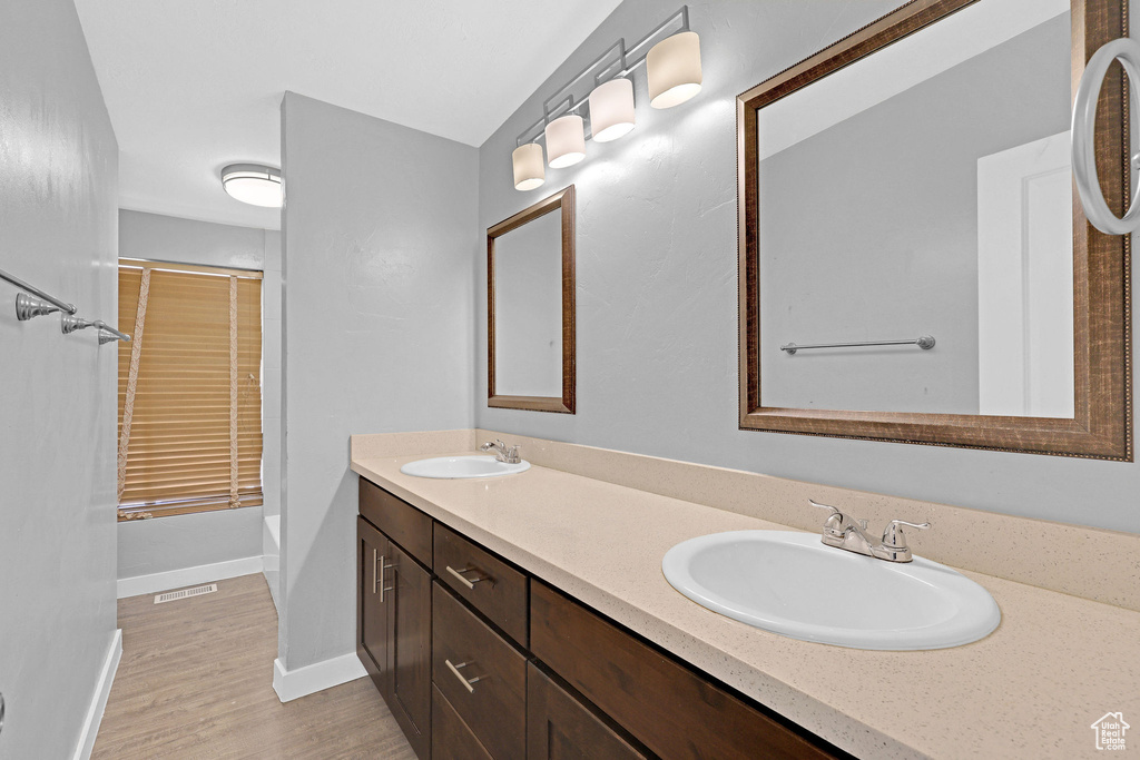 Bathroom with hardwood / wood-style flooring and dual bowl vanity