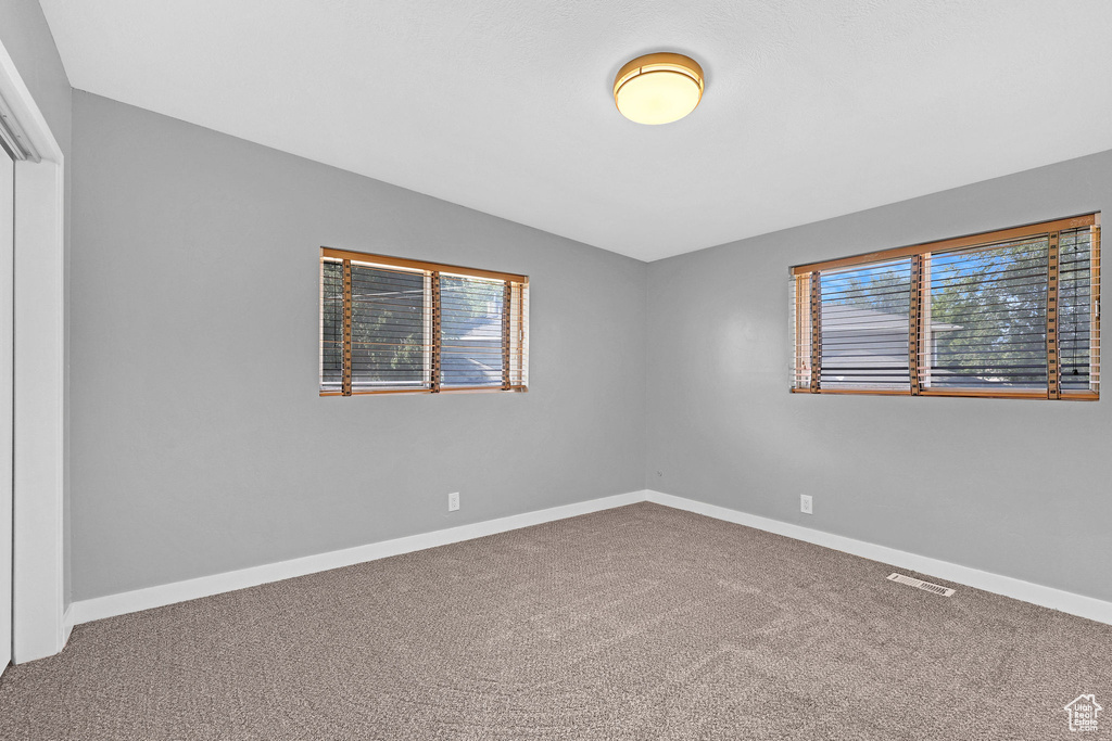 Unfurnished room featuring carpet floors and vaulted ceiling