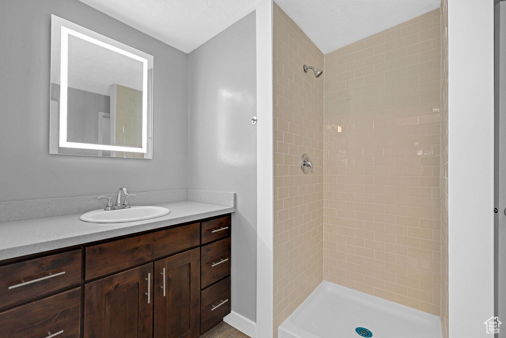 Bathroom featuring vanity and a tile shower