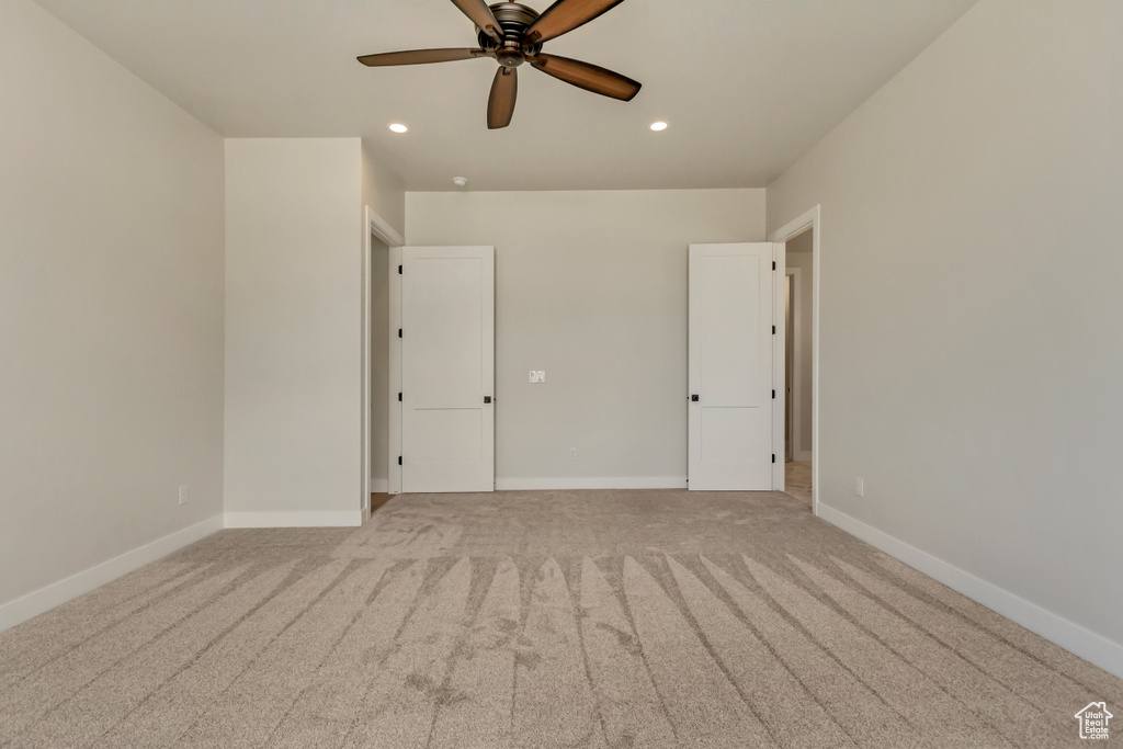 Empty room featuring ceiling fan and light carpet