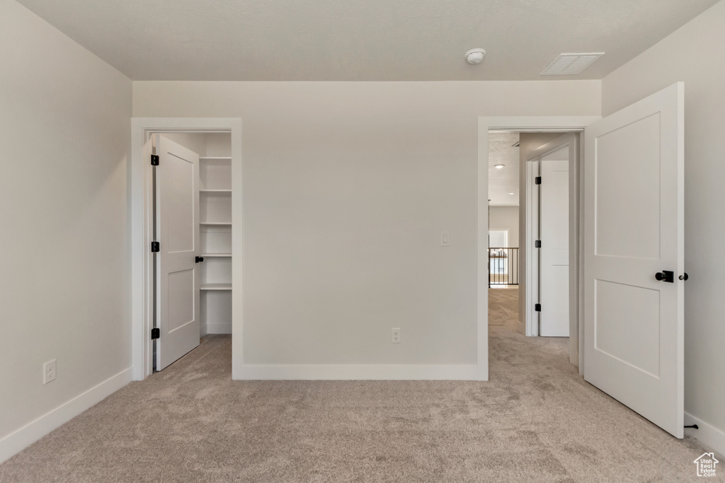 Unfurnished bedroom with light carpet