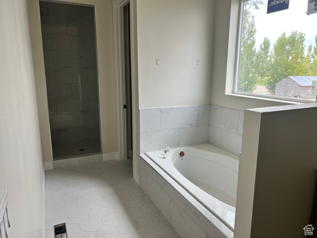 Bathroom featuring plus walk in shower and tile patterned flooring