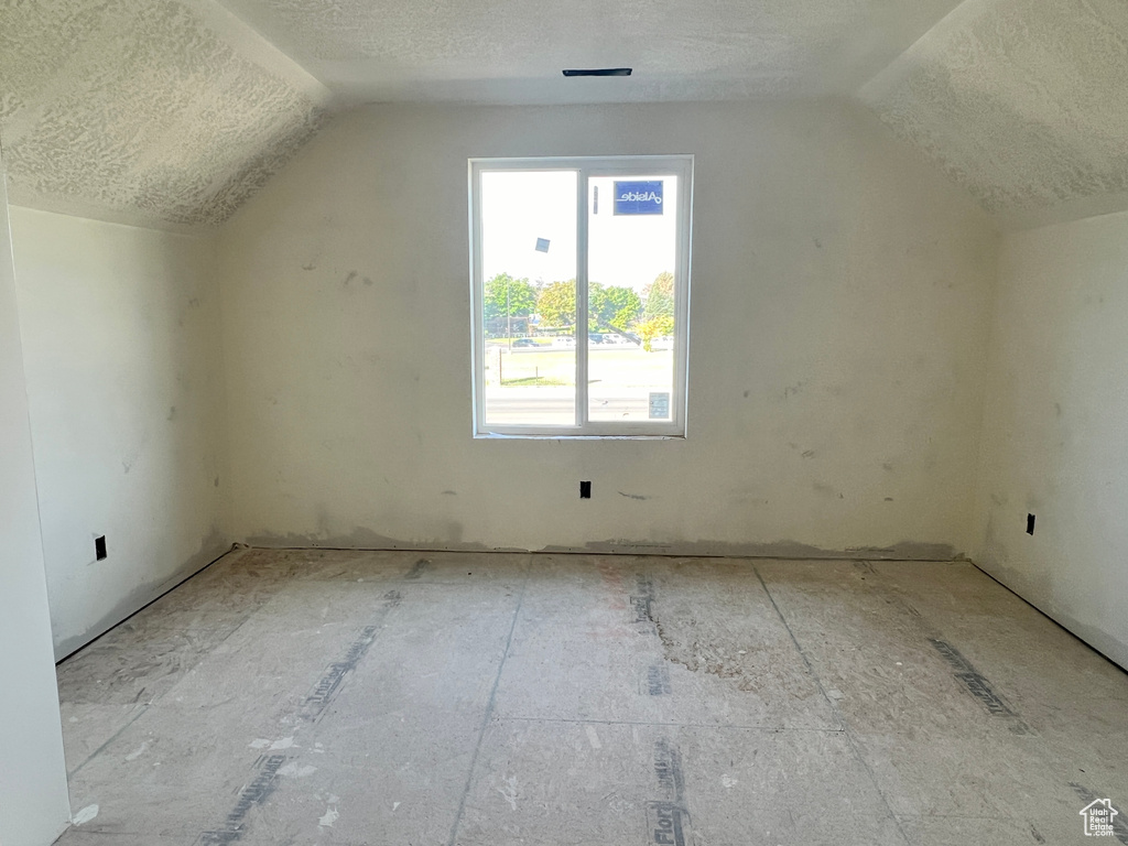 Bonus room with a textured ceiling and lofted ceiling