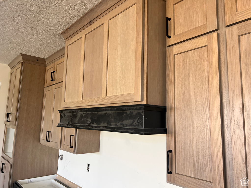 Kitchen featuring light brown cabinets and a textured ceiling