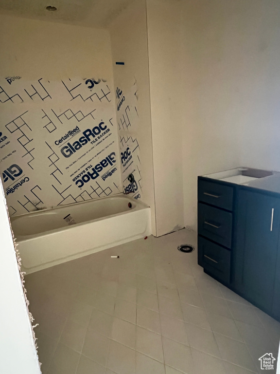 Bathroom featuring a bathing tub, vanity, and tile patterned floors