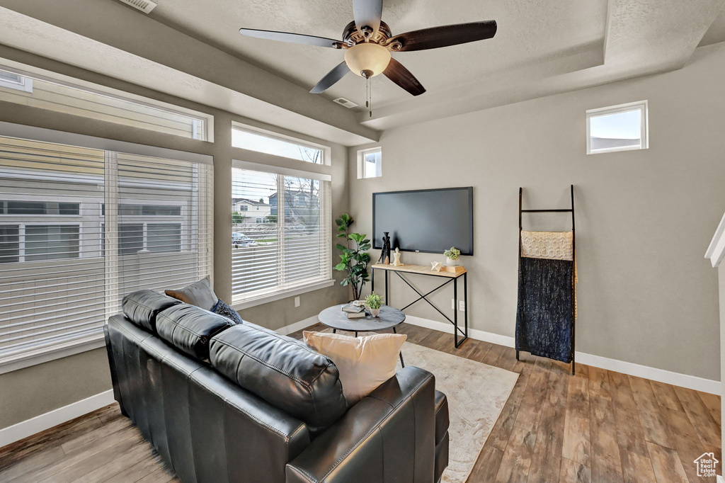 Living room with plenty of natural light, hardwood / wood-style flooring, and ceiling fan