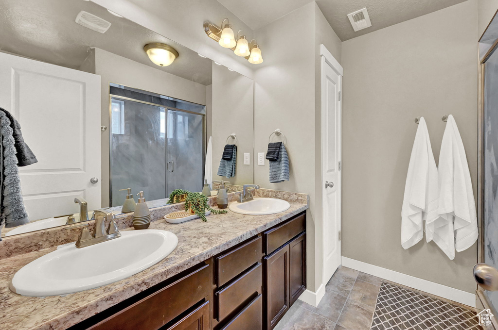 Bathroom featuring tile patterned floors and double vanity