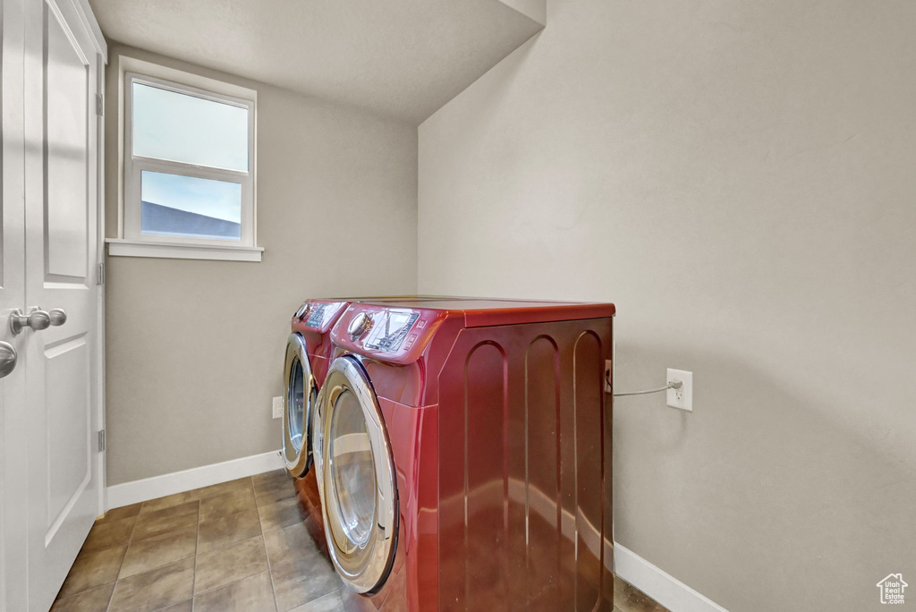 Washroom with separate washer and dryer and tile patterned flooring