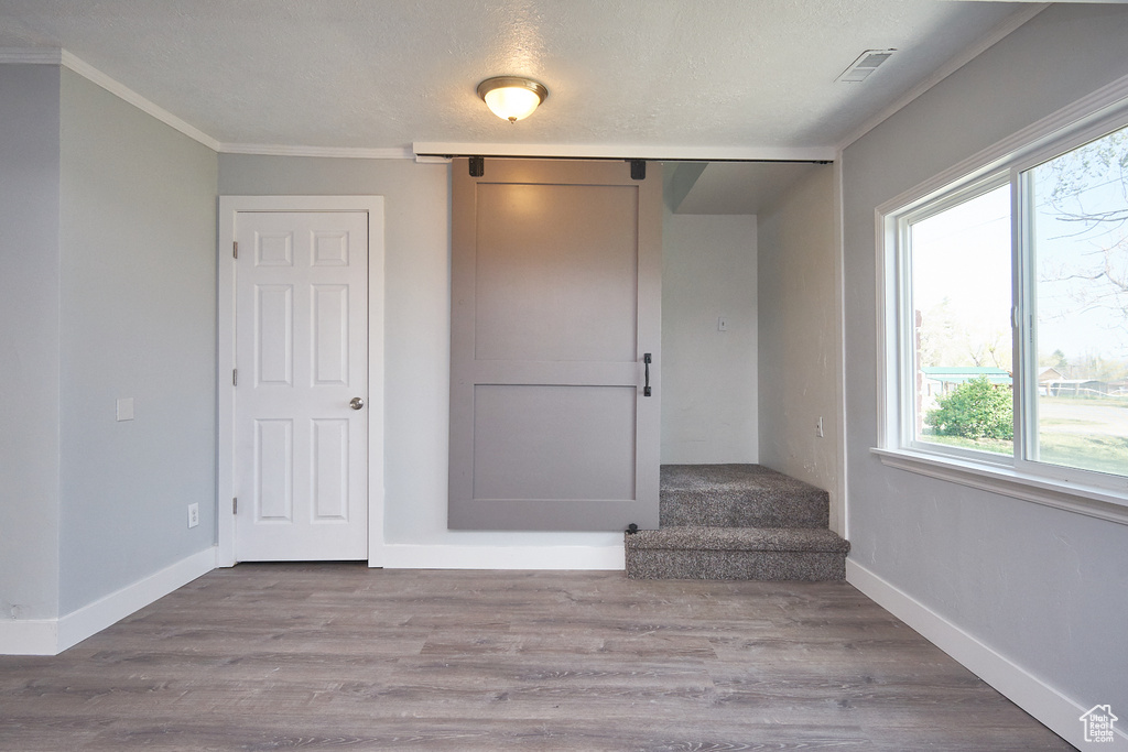 Stairs featuring hardwood / wood-style flooring, a textured ceiling, and ornamental molding