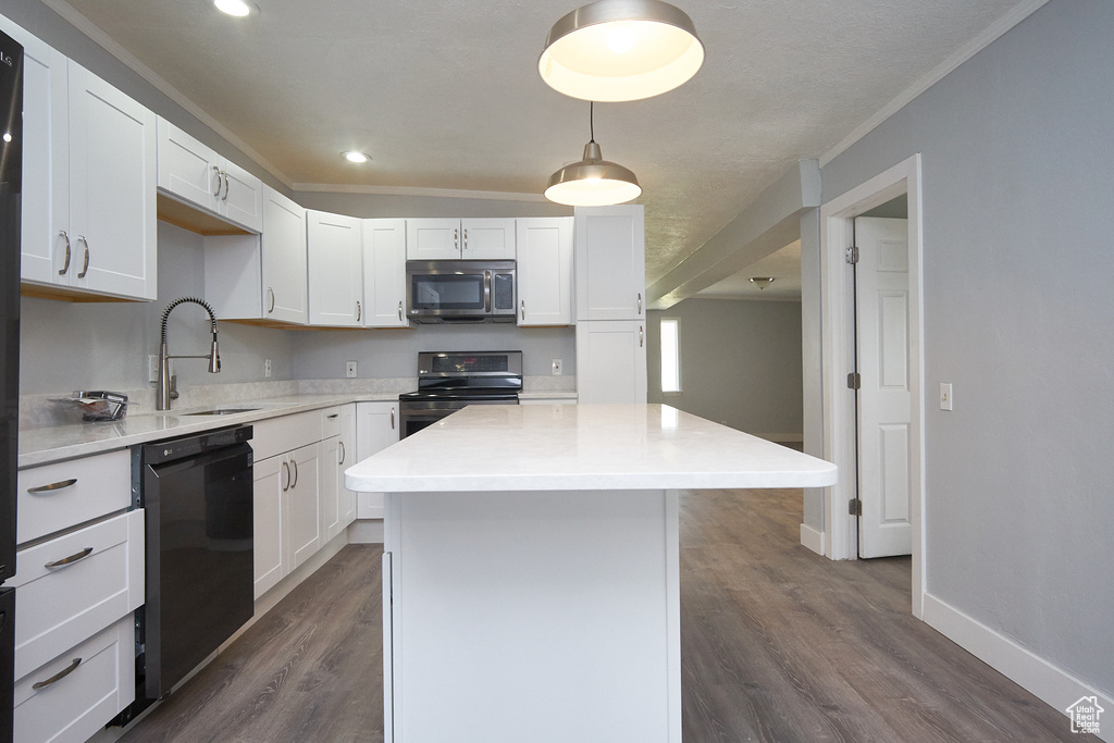 Kitchen with decorative light fixtures, dark hardwood / wood-style flooring, sink, a kitchen island, and appliances with stainless steel finishes