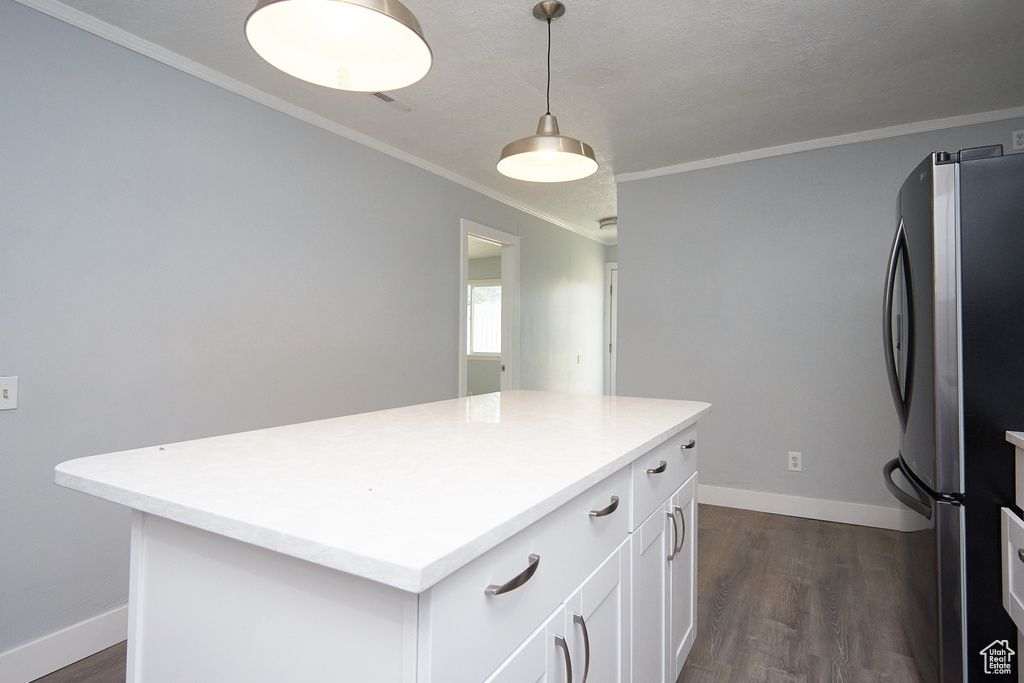 Kitchen featuring white cabinetry, a center island, dark wood-type flooring, pendant lighting, and stainless steel fridge