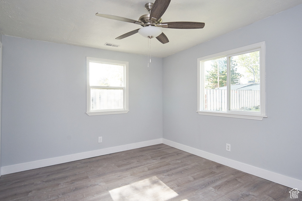 Empty room featuring hardwood / wood-style flooring and ceiling fan