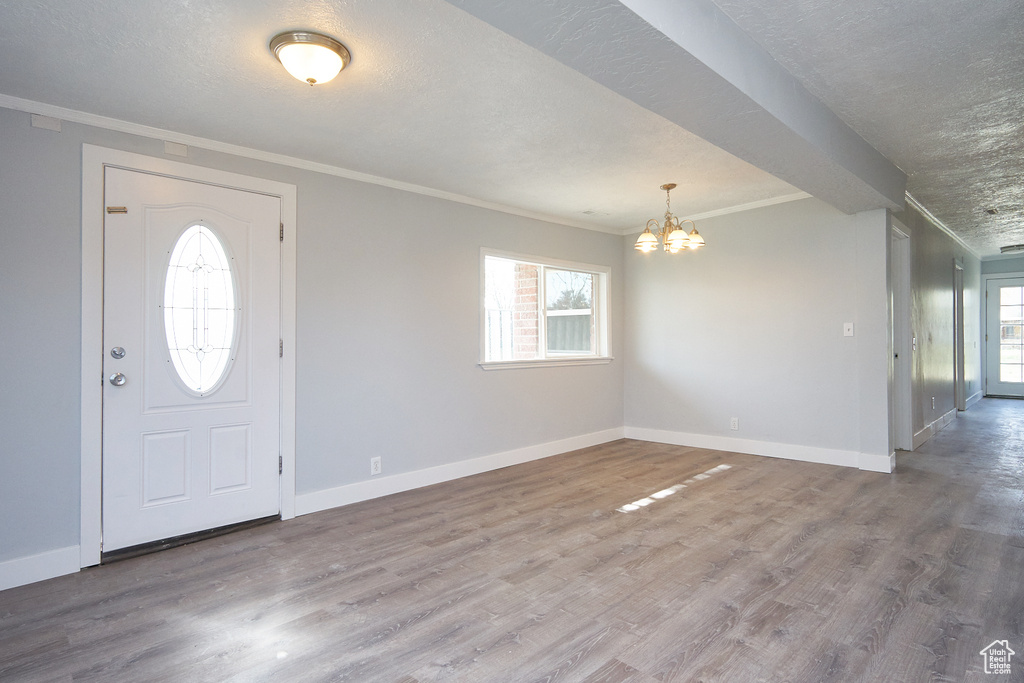 Foyer featuring an inviting chandelier, a textured ceiling, and hardwood / wood-style flooring