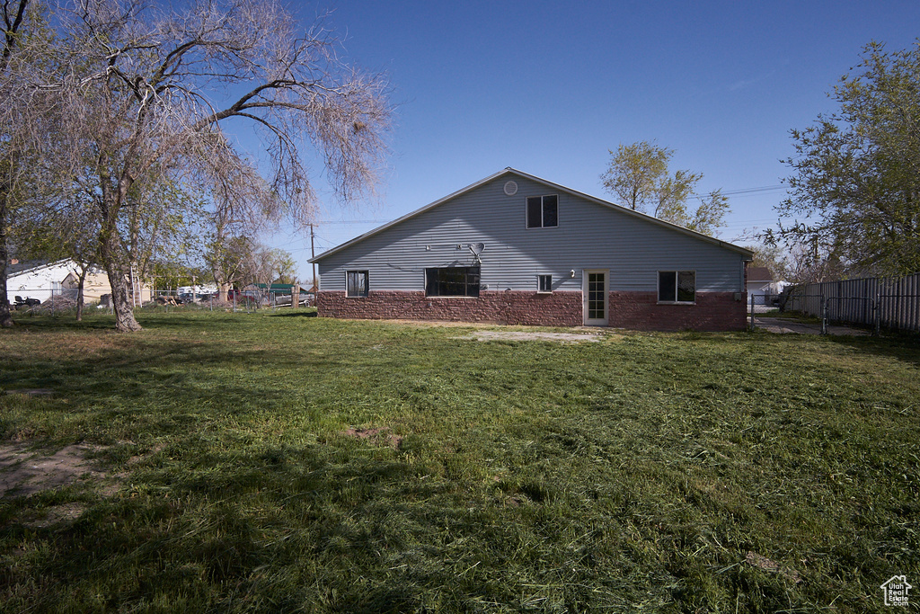 Back of property featuring a lawn