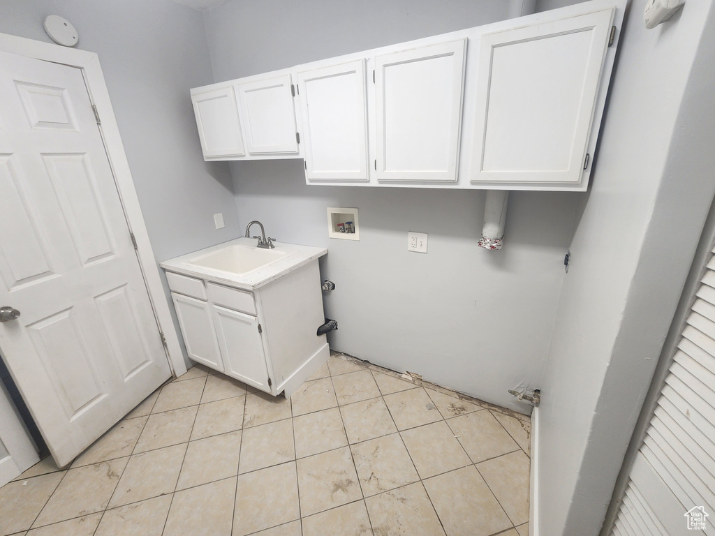 Laundry room featuring light tile patterned flooring, cabinets, washer hookup, and sink