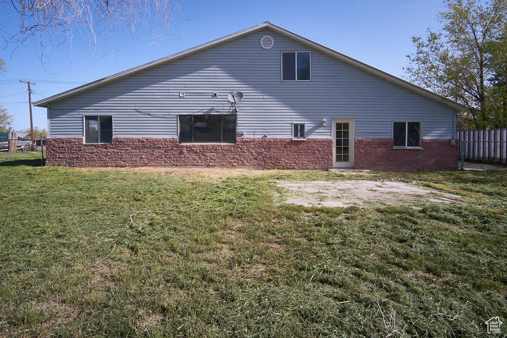 Back of property featuring a lawn