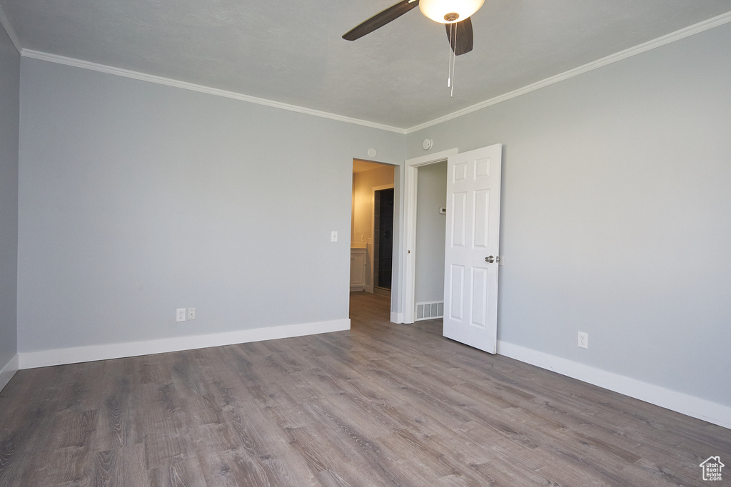 Empty room with crown molding, hardwood / wood-style floors, and ceiling fan