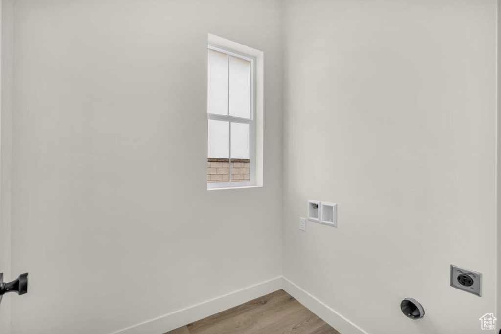 Washroom featuring hookup for a washing machine, hookup for an electric dryer, and light hardwood / wood-style floors