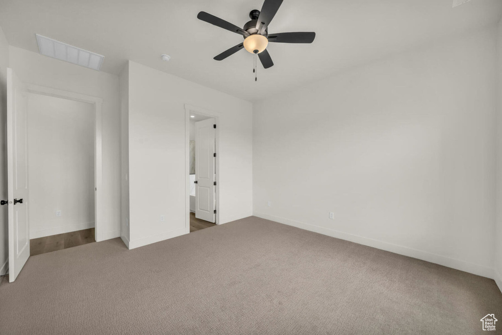 Unfurnished bedroom with carpet flooring, ensuite bath, and ceiling fan