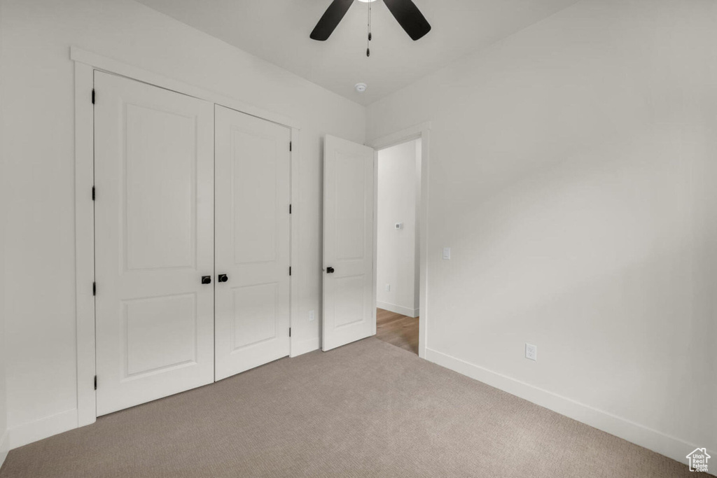 Unfurnished bedroom with a closet, carpet floors, and ceiling fan