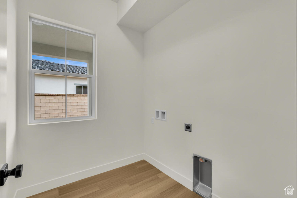 Laundry room featuring hardwood / wood-style flooring, hookup for an electric dryer, and washer hookup