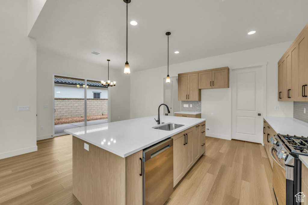 Kitchen with sink, appliances with stainless steel finishes, a center island with sink, and light hardwood / wood-style floors