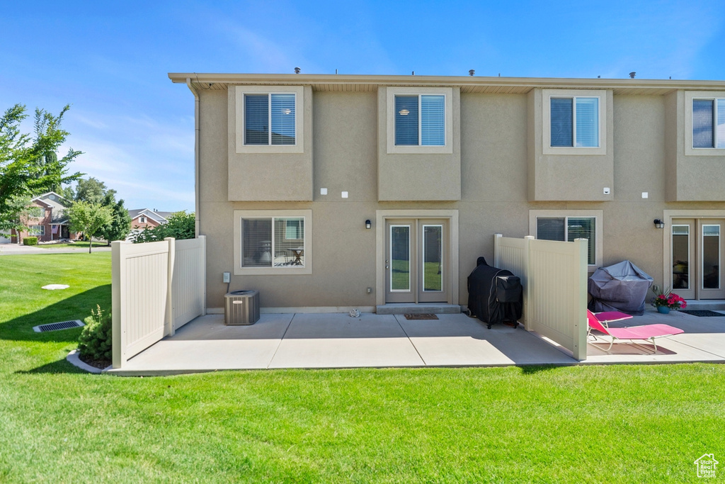 Back of house featuring french doors, a lawn, a patio area, and central air condition unit