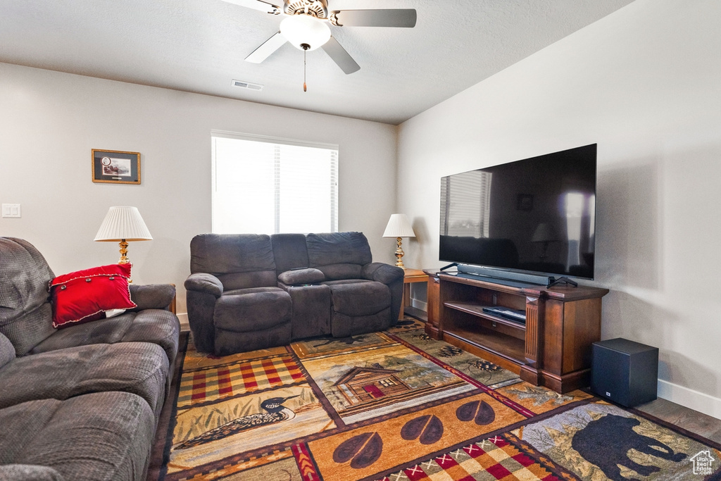 Living room featuring ceiling fan and dark hardwood / wood-style flooring