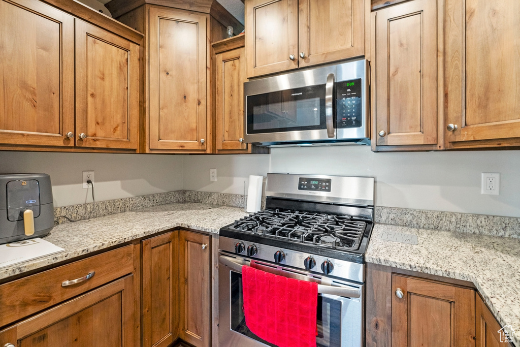 Kitchen featuring light stone countertops and appliances with stainless steel finishes