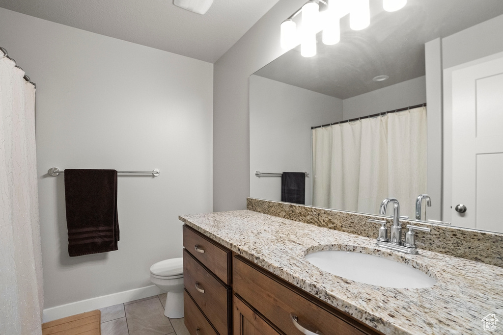 Bathroom with tile floors, large vanity, and toilet