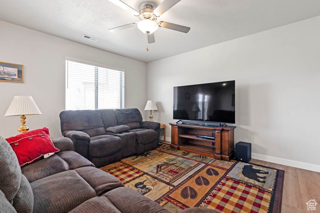 Living room featuring ceiling fan and hardwood / wood-style flooring