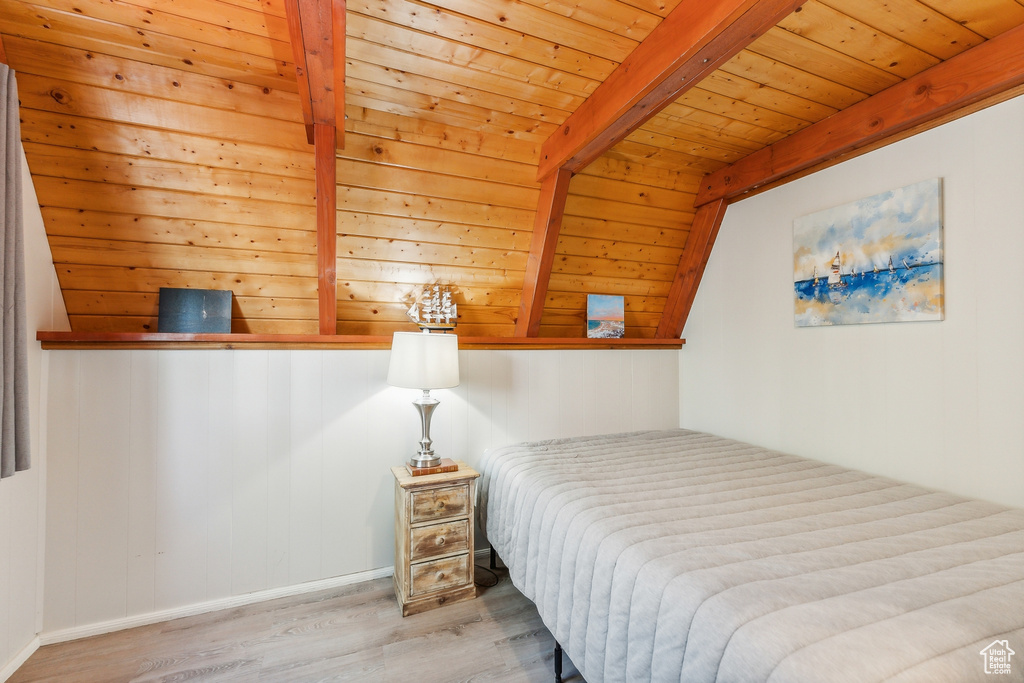 Bedroom featuring wood ceiling, light hardwood / wood-style floors, and vaulted ceiling with beams